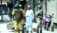 Paramilitary troopers stop a resident during a curfew and strike in Srinagar, yesterday.
