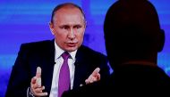 A journalist watches a live broadcast on an electronic screen showing nationwide call-in attended by Russian President Vladimir Putin, in Moscow, Russia, June 15, 2017. REUTERS/Sergei Karpukhin