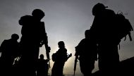 This photo taken on February 28, 2009 shows US soldiers with the NATO-led International Security Assistance Force (ISAF) silhouetted as they walk during a patrol outside Bagram Airbase, some 50 km north of Kabul. Three American troops were wounded on June