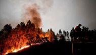 A firefighter stands on top of a fire combat truck during a wildfire at Penela, Coimbra, central Portugal, on June 18, 2017 A wildfire in central Portugal killed at least 25 people and injured 16 others, most of them burning to death in their cars, the go