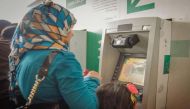 A woman withdrawing cash from an ATM machine.