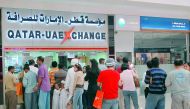 Expats standing in queue at an exchange house to send money to relatives back home.
