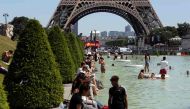 People refresh themselves in the Trocadero fountain in Paris, on June 19, 2017, as the French capital is placed on heatwave alert as temperatures are set to soar in the coming days. / AFP / LUDOVIC MARIN
