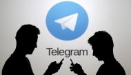 FILE PHOTO: Men pose with smartphones in front of a screen showing the Telegram logo in this picture illustration November 18, 2015. REUTERS/Dado Ruvic/File Photo

