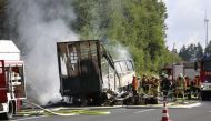 Firefighters work at the scene where a tour bus burst into flames following a collision with a trailer truck on the highway A9 near Münchberg, southern Germany, on July 3, 2017, where up to 17 people are feared dead. AFP.