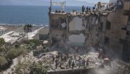 Firefighters throw away the debris of a collapsed building on the binaries of the railway after two floors collapsed in a small four-storey building in Torre Annunziata, a town near the Italian city of Naples, on July 7, 2017. / AFP / Renato Esposito.