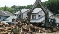 Defence forces soldiers remove debris in a flooded area in Asakura, Fukuoka prefecture on July 9, 2017. / AFP.