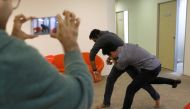 Employees of Graymatics, a company known for its digital video analysis and image-recognition technology,  pretend to fight as they record footage to be used to train their software to watch and filter internet videos for violence at their office in Singa