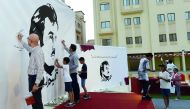 People write messages on 'Tamim Al Majd' murals at Ezdan Village 2 in Al Gharrafa yesterday.