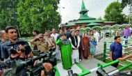 Jammu and Kashmir Chief Minister Mehbooba Mufti (in green) salutes at the martyrs' graveyard during an event to mark 