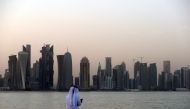A man looks at his phone on the corniche of the Qatari capital Doha on July 2, 2017 (AFP)