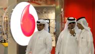 Men walk past a Vodafone-Qatar Telecommunication office in Doha October 22,2009. Reuters / Fadi Al-Assaad