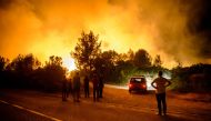 Local men look on during the extinguishing operation in Tivat, Montenegro on July 18, 2017. 150 fire department workers, soldiers and local people mobilized to extinguish the forest fires in Western Balkan countries; Montenegro, Croatia and Bosnia and Her