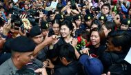 Ousted Thai prime minister Yingluck greets her supporters as she leaves the Supreme Court in Bangkok, Thailand, yesterday.
