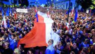 People raise candles and hold a Polish flag  during a protest in front of the Presidential Palace, in Warsaw, yesterday.