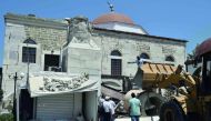 Workers remove rubble from a quake-damaged mosque in the central square of the Greek Island of Kos, yesterday.