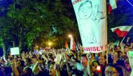 Protesters hold candles and shout slogans as they take part in a demonstration in front of the Polish Parliament.