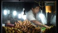 In this photograph taken on on July 23, 2017, a man sells food near the Galle fort at night in Galle.  AFP /  Ishara S Kodikara
