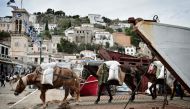 Mules transport goods from commercial ferry on the Greek island of Hydra on November 12, 2016.  AFP / Louisa Gouliamaki