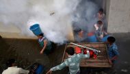 A municipal worker fumigates a flooded alley to prevent the spread of dengue fever and other mosquito-borne diseases, at a residential colony in Ahmedabad, India, July 29, 2017. Reuters/Amit Dave

