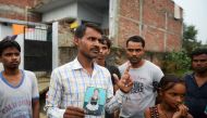 Mohammad Zahid, who lost his five-and-a-half year old daughter Khushi, holds his daughter's photograph in Gorakhpur in the Indian state of Uttar Pradesh, on August 14, 2017. AFP / Sanjay Kanojia