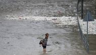 A man walks through a flooded street as Typhoon Hato hits Hong Kong, China August 23, 2017. REUTERS/Tyrone Siu
