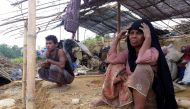 (FILES) This file photo taken on May 31, 2017 shows Rohingya refugees sitting near a house destroyed by Cyclone Mora in a camp in the Cox's Bazar district.   AFP / STR
