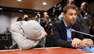 Suspect Mohamed Bakier allegedly involved in the Finnish stabbing attack covers himself next to jis lawyer Joni Brander in the Southwest Finland District Court during the remand hearing on August 22, 2017 in Turku, Finland.   AFP / Lehtikuva / Martti Kain