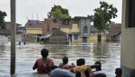 Indian residents wade through flood waters in Malda in the Indian state of West Bengal on August 24, 2017.  AFP / DIPTENDU DUTTA
