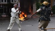 A follower of Indian religious leader Gurmeet Ram Rahim Singh pleads for his safety after being hit with a stick during clashes between the controversial guru's followers and security forces in Panchkula on August 25, 2017.  AFP / Money Sharma

