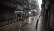 A man uses an umbrella during heavy rain as severe tropical storm Pakhar passes over Macau on August 27, 2017. / AFP.