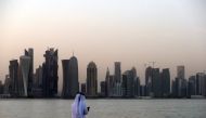 A man looks at his phone on Doha corniche (AFP / file photo)