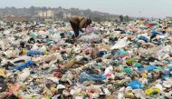 A man searches through waste at the Ngong town dumping site, 30 kilometres southwest of Nairobi, on August 24, 2017. AFP / SIMON MAINA
