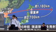 TOPSHOT - Pedestrians walk in front of a huge screen displaying a map of Japan (R) and the Korean Peninsula, in Tokyo on August 29, 2017, following a North Korean missile test that passed over Japan.  AFP / Kazuhiro NOGI
