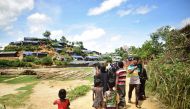 Newly arrived Rohingya refugees walk past the Balukhali Rohingya camp near Ukhiya on the Bangladesh border, on August 27, 2017,  after violence erupted in bordering Myanmar's Rakhine state. AFP / Sam Jahan