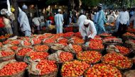 People walk past baskets of tomatoes in the Yankaba market in Kano, northwest Nigeria August 23, 2017. Picture taken August 23, 2017 REUTERS/Akintunde Akinleye.