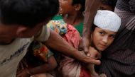 A Rohingya refugee boy is stopped by volunteers as he jostles to receive food distributed by local organizations in Kutupalong, Bangladesh, September 9, 2017. Reuters/Danish Siddiqui         