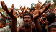 FILE PHOTO: Rohingya refugees stretch their hands to receive food distributed by local organizations in Kutupalong, Bangladesh, September 9, 2017. REUTERS/Danish Siddiqui.