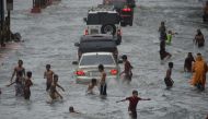 Young residents play on a flooded street in Manila on September 12, 2017, after tropical depression locally codenamed 