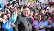 This undated picture released from North Korea's official Korean Central News Agency (KCNA) on September 12, 2017 shows North Korean leader Kim Jong-Un (C) attending a photo session with teachers who volunteered to work at branch schools on islands and sc