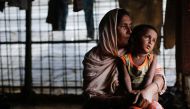 A Rohingya refugee woman waits for aid with her grandson inside their temporary shelter at a camp in Cox's Bazar, Bangladesh September 19, 2017. Reuters/Danish Siddiqui