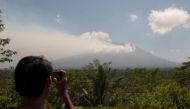 A local resident takes a picture of Mount Agung, an active volcano that authorities say is showing increased activity, from a monitoring station in Rendang Village, Karangasem on the resort island of Bali, Indonesia September 19, 2017. / Reuters.