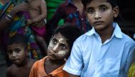 This photograph taken on September 21, 2017 shows Hindu boys wearing traditional cosmetics stand in the yard of a IDP camp for Hindu at the Sri Sri Moha Dev Bari Hindu Temple in Sittwe, in Myanmar's Rakhine state. AFP / Aidan JONES