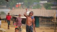 A Rohingya man, fled from oppression within ongoing military operations in Myanmar’s Rakhine state, walks through the mud along with a kid as they take shelter at a makeshift camp in Cox's Bazar, Bangladesh on September 24, 2017. (Zakir Hossain Chowdhury 
