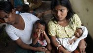 20-year-old Hindu girl, Chaw Shaw Chaw Thee (R) sits with her newborn baby, her husband and their young son at a shelter for refugees in Sittwe, on September 22, 2017. Chaw shaw Chaw Thee fears that twenty-three members of her family are dead, after Myanm