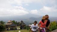 Tourists walk up the stairs at Penataran Agung Lempuyang Temple with Mount Agung, a volcano on the highest alert level, in the background in Karangasem Regency on the resort island of Bali, Indonesia September 25, 2017. Reuters/Darren Whiteside