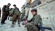 A fighter from Syrian Democratic Forces (SDF) sits on a curb as he holds his weapon in Raqqa, yesterday.