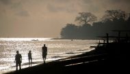 Tourists walk on Amed beach in Karangasem on the Indonesian resort island of Bali on September 30, 2017. AFP / BAY ISMOYO

