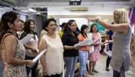 Unsung Heroes choir founder Jane Englemann leads her group of Filipina domestic workers during a practice session inside a kindergarten school's classroom in Hong Kong on Sept 3, 2017. PHOTO: AFP.