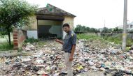 In this photograph taken on August 20, 2017, Durgesh Mishra stands near a dumpsite as he speaks during an interview with an AFP reporter in Gonda district, in the Indian state of Uttar Pradesh. AFP / SAJJAD HUSSAIN 